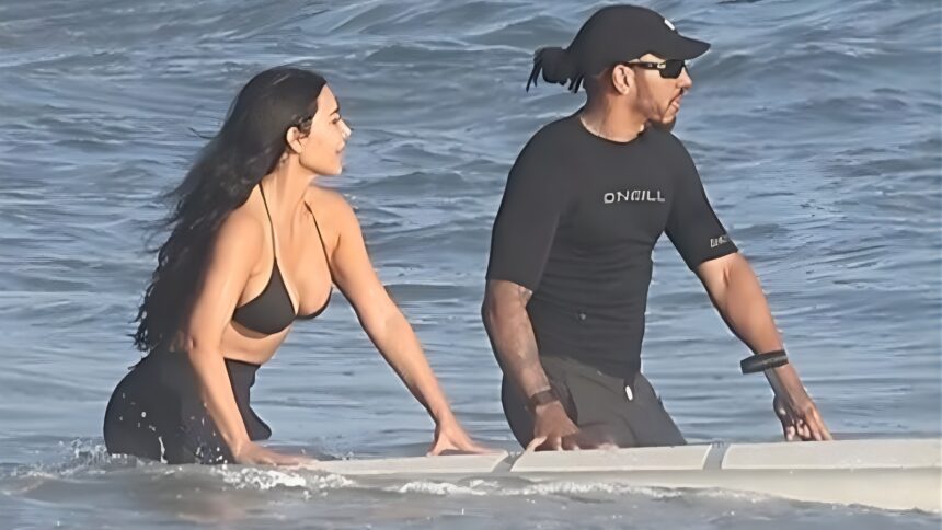 Kim Kardashian and Lewis Hamilton kissing in the ocean during a Malibu beach day, wearing swimwear and enjoying a romantic moment