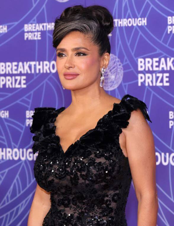 Salma Hayek wearing a sleek updo with visible gray hair at the Breakthrough Prize red carpet event