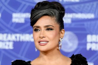 Salma Hayek wearing a sleek updo with visible gray hair at the Breakthrough Prize red carpet event