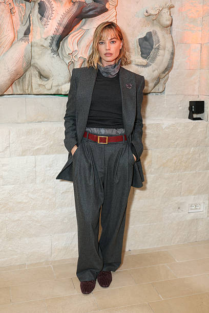 Margot Robbie wearing a charcoal gray Giorgio Armani suit with brooch at Milan Design Week sciura style look