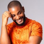 Alex Ekubo smiling during a Nollywood event as Rita Dominic, Mercy Johnson, and other celebrities mourn his reported death online.