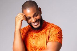 Alex Ekubo smiling during a Nollywood event as Rita Dominic, Mercy Johnson, and other celebrities mourn his reported death online.