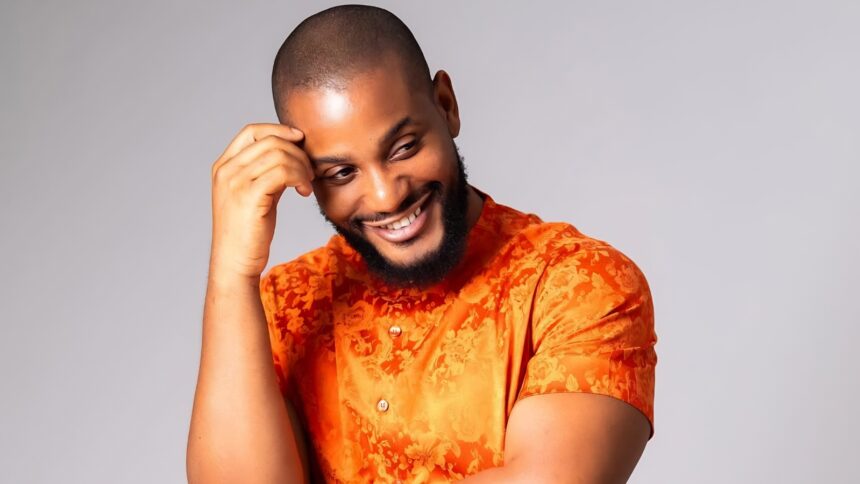Alex Ekubo smiling during a Nollywood event as Rita Dominic, Mercy Johnson, and other celebrities mourn his reported death online.