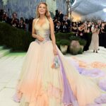 Blake Lively at the Met Gala adjusting her gown train while giving instructions to assistants on the red carpet, sparking viral debate