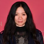 Director Chloé Zhao wearing an elegant black lace and knit dress with a leather moto jacket at the Cannes Film Festival red carpet.