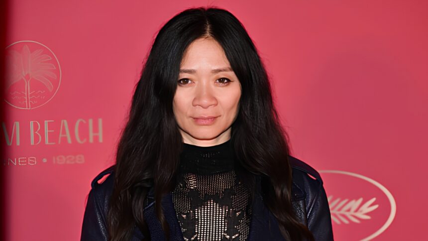 Director Chloé Zhao wearing an elegant black lace and knit dress with a leather moto jacket at the Cannes Film Festival red carpet.