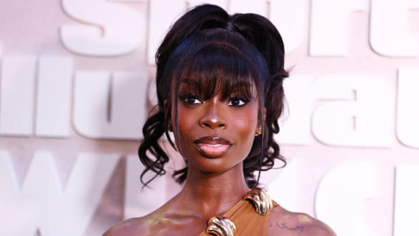Olandria Carthen wearing a sleek Party Ponytail hairstyle with long bangs and a glamorous sheer dress at the Sports Illustrated Swimsuit launch party in New York City.