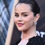 Selena Gomez wearing a sleek bun and classic bright red nail polish at the Los Angeles premiere of Marty, Life Is Short in a black beaded Carolina Herrera dress